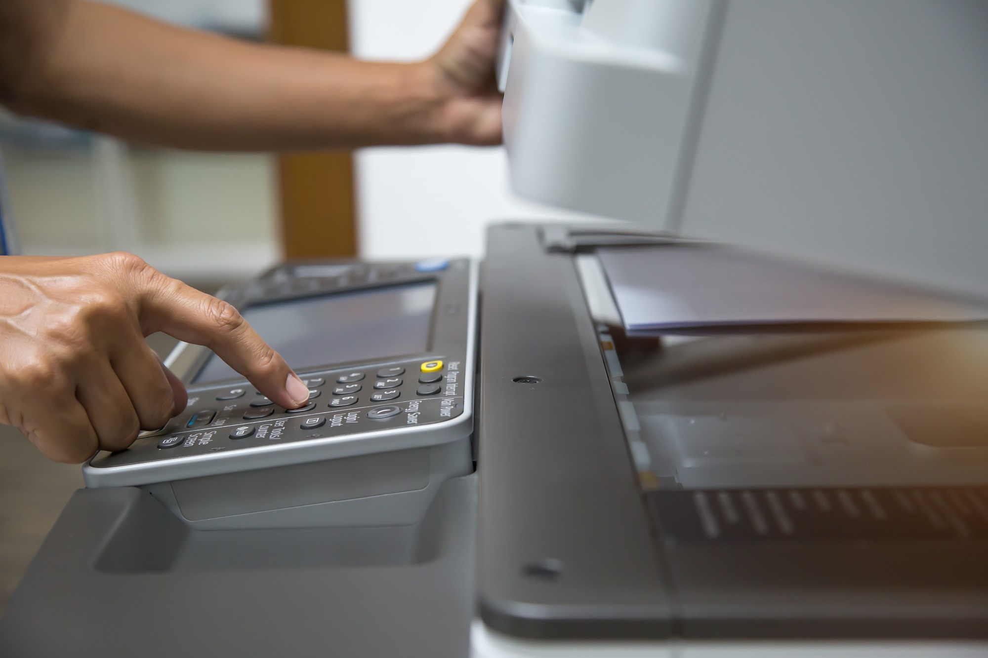 closeup hand press button to using the photocopier or xerox machine